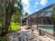 Stone pathway leads to screened-in pool with landscaped surroundings at 3905 Country View Dr, Sarasota, FL 34233