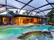 A screened pool area offers a view of the home's exterior with an outdoor dining space under the covered patio at 3905 Country View Dr, Sarasota, FL 34233