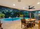 The pool is surrounded by a screened lanai, creating a private oasis for dining and relaxation with integrated ceiling fan at 3905 Country View Dr, Sarasota, FL 34233