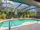 This inviting pool and spa area, enclosed with a screened-in structure, is surrounded by lush, tropical landscaping at 3905 Country View Dr, Sarasota, FL 34233