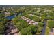 An aerial view of the community featuring a picturesque lake, lush greenery, and a variety of home styles at 3919 Glen Oaks Manor Dr, Sarasota, FL 34232