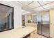 Kitchen featuring stainless steel refrigerator, eat-in bar, and a view to the living and dining areas at 3919 Glen Oaks Manor Dr, Sarasota, FL 34232
