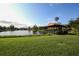 Lakeside view of a charming gazebo surrounded by trees, offering a peaceful retreat at 3919 Glen Oaks Manor Dr, Sarasota, FL 34232