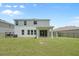 Back of house with grassy backyard and black aluminum fence at 4015 Quiet Rain Ct, Palmetto, FL 34221