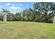 Expansive backyard featuring a well-maintained lawn and a wooded backdrop at 4015 Quiet Rain Ct, Palmetto, FL 34221