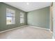Serene bedroom featuring neutral tile floors, two large windows providing natural light, and painted in a calming green tone at 4015 Quiet Rain Ct, Palmetto, FL 34221