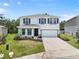 Attractive two-story home featuring a manicured lawn, front porch, two-car garage, and complementary dark shutters at 4015 Quiet Rain Ct, Palmetto, FL 34221