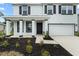 Charming two-story home with a well-manicured lawn and a welcoming front porch, garage, and decorative shutters at 4015 Quiet Rain Ct, Palmetto, FL 34221