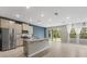 Modern kitchen with stainless steel appliances, granite countertops, and an island overlooking the living area at 4015 Quiet Rain Ct, Palmetto, FL 34221