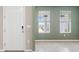 Bright, open-concept living room featuring large windows, tile flooring, and a refreshing light green wall color at 4015 Quiet Rain Ct, Palmetto, FL 34221