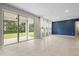 Open living room with sliding glass doors leading to back yard, and blue accent wall at 4015 Quiet Rain Ct, Palmetto, FL 34221