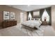 Comfortable main bedroom with neutral paint, carpet, bench, lamps, and elegant decor at 4015 Quiet Rain Ct, Palmetto, FL 34221