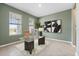 This home office has a large glass and wood desk, neutral color walls, and a large picture on the wall at 4015 Quiet Rain Ct, Palmetto, FL 34221