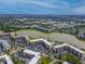 Scenic aerial view of the condo complex with lake, lush landscaping, and ample parking at 4189 Heron Way # 406E, Bradenton, FL 34205