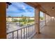 Balcony with parking area view and landscaping with tropical palm trees and surrounding buildings at 4189 Heron Way # 406E, Bradenton, FL 34205