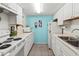 Compact kitchen features white appliances and cabinets, accented by a unique blue wall at 4189 Heron Way # 406E, Bradenton, FL 34205