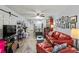 Spacious living area featuring hardwood floors, a comfortable red sofa, and a dining area at 4189 Heron Way # 406E, Bradenton, FL 34205