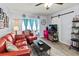 Relaxing living room with a comfortable red sofa, modern decor, and ample natural light at 4189 Heron Way # 406E, Bradenton, FL 34205