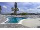 Community pool with several lounge chairs and clear blue skies at 4189 Heron Way # 406E, Bradenton, FL 34205