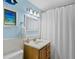 Bathroom boasts a classic vanity with a white shower curtain and blue accents at 4310 Falmouth Dr # 105, Longboat Key, FL 34228