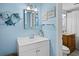 Bathroom features a modern white vanity, a decorative fish, and calming blue walls at 4310 Falmouth Dr # 105, Longboat Key, FL 34228