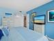 Bright bedroom with blue walls, white furniture, and a beach-themed decor at 4310 Falmouth Dr # 105, Longboat Key, FL 34228