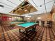 Classic billiards room featuring two pool tables, brick accent wall and wood paneled walls at 4310 Falmouth Dr # 105, Longboat Key, FL 34228