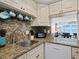 Well-lit kitchen features granite counters and stainless steel appliances with a view to the living room at 4310 Falmouth Dr # 105, Longboat Key, FL 34228