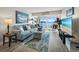 Spacious living room with a comfortable blue couch, plush rug, and sliding glass doors with water views at 4310 Falmouth Dr # 105, Longboat Key, FL 34228