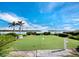 Scenic putting green overlooking the water and a bench, set in a tropical landscape at 4310 Falmouth Dr # 105, Longboat Key, FL 34228