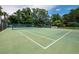 Well-maintained tennis court surrounded by lush greenery and fencing at 4310 Falmouth Dr # 105, Longboat Key, FL 34228