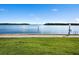 Picturesque waterfront view with a well-maintained grassy area, calm waters, and clear blue sky at 4310 Falmouth Dr # 105, Longboat Key, FL 34228