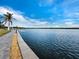 Scenic waterfront view with a paved walkway, palm trees, and calm blue water at 4310 Falmouth Dr # 105, Longboat Key, FL 34228