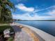 Picturesque waterfront walkway with palm trees, lush landscaping, and a tranquil view at 4310 Falmouth Dr # 105, Longboat Key, FL 34228