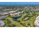 Stunning aerial view of community condos, a golf course, and tranquil ponds creating a picturesque residential setting at 4550 Pinebrook Cir # 608, Bradenton, FL 34209