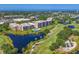 Beautiful aerial showcasing condos, a community pool, and a scenic pond in a lush, landscaped environment at 4550 Pinebrook Cir # 608, Bradenton, FL 34209