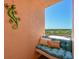 Cozy balcony seating area with decorative pillows and a mounted lizard sculpture creating a relaxing outdoor space at 4550 Pinebrook Cir # 608, Bradenton, FL 34209