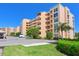View of the exterior of the condo building with lush landscaping and parking spaces at 4550 Pinebrook Cir # 608, Bradenton, FL 34209