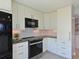 Modern kitchen with black appliances, white cabinetry, and granite countertops at 4550 Pinebrook Cir # 608, Bradenton, FL 34209
