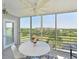 Bright lanai with floor-to-ceiling windows showcasing panoramic golf course views and modern furniture at 4550 Pinebrook Cir # 608, Bradenton, FL 34209