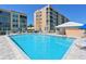 Inviting community pool with clear blue water, lounge chairs, and umbrellas, perfect for relaxation at 4550 Pinebrook Cir # 608, Bradenton, FL 34209