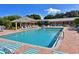 Community pool with brick paved deck surrounded by mature landscaping and comfortable lounge chairs at 4550 Pinebrook Cir # 608, Bradenton, FL 34209