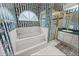 Vintage bathroom featuring floral wallpaper, a bathtub, and a shower with gold frame at 4621 34Th E Ct, Bradenton, FL 34203
