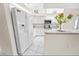 Bright kitchen featuring white cabinets, modern appliances, tiled flooring, and a breakfast bar at 4621 34Th E Ct, Bradenton, FL 34203
