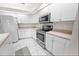 Bright kitchen with white cabinetry, stainless steel appliances, and tile flooring at 4621 34Th E Ct, Bradenton, FL 34203