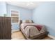 Cozy bedroom featuring a platform bed, hardwood floors, and a window, creating a serene retreat at 4718 Arbor Gate Dr, Bradenton, FL 34203