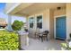 Inviting front porch with rocking chairs, a small water fountain, and a blue front door at 4718 Arbor Gate Dr, Bradenton, FL 34203