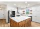 Bright kitchen featuring a large island, stainless steel appliances, white cabinets, and hardwood floors at 4718 Arbor Gate Dr, Bradenton, FL 34203