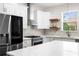 Bright kitchen featuring stainless steel appliances, white cabinets, a modern backsplash, and a view of the outdoors at 4718 Arbor Gate Dr, Bradenton, FL 34203