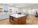 Open-concept kitchen with central island, white cabinetry, and stainless steel appliances, flowing into dining and living areas at 4718 Arbor Gate Dr, Bradenton, FL 34203